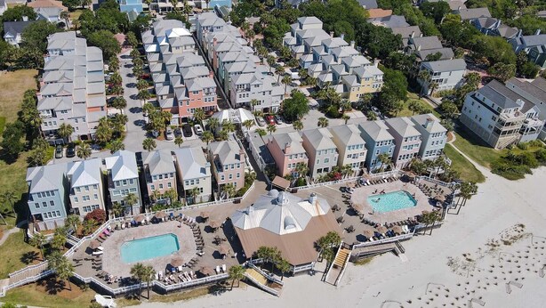 A resort with multiple hotel buildings, a swimming pool, and a beach area.