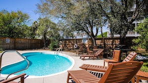 A backyard with a swimming pool, wooden deck, and outdoor furniture. - Pet friendly home with pool, billiard table; across the street from beach. (Isle of Palms)