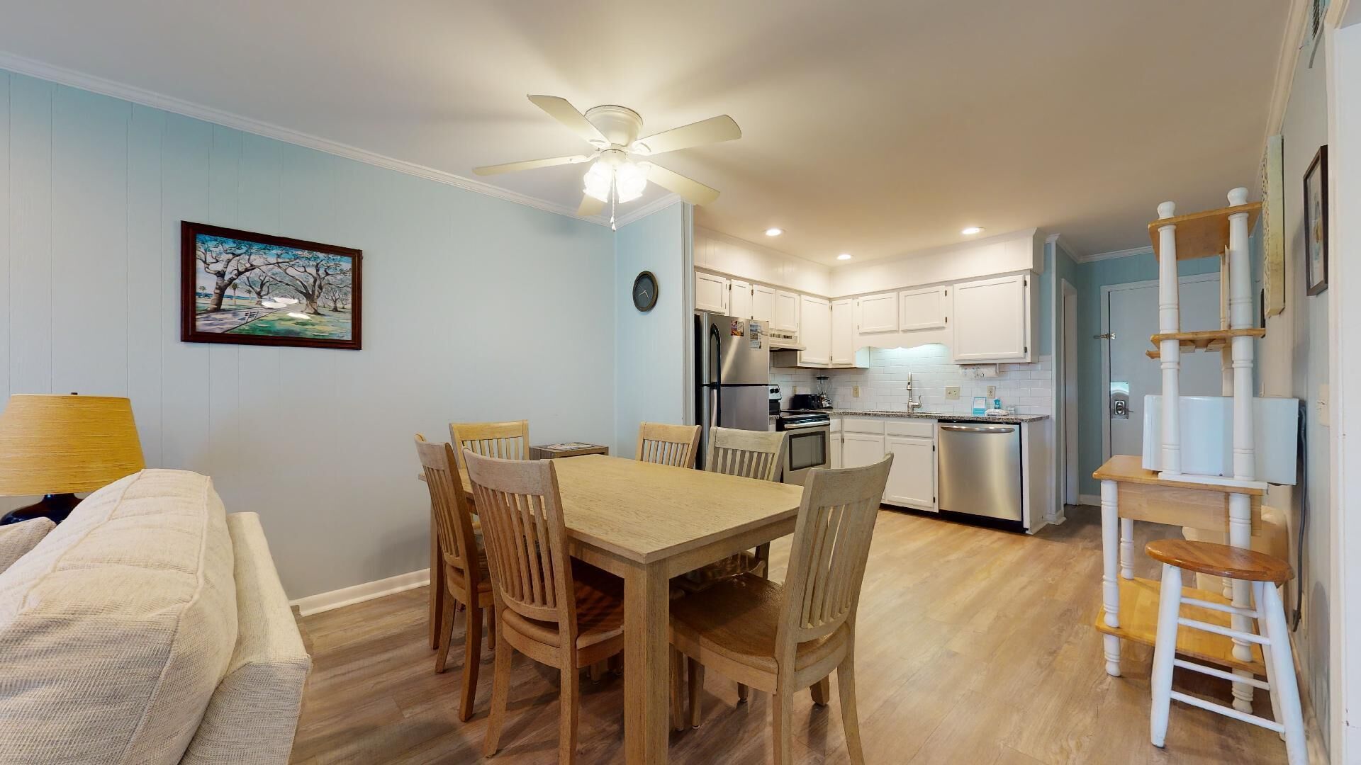 Un espace de vie compact comprenant un coin repas, une kitchenette et un petit escalier.