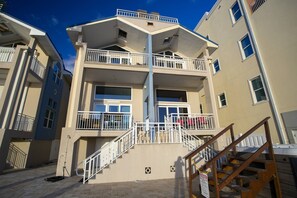 A multi-story building with balconies, a staircase, and a sign indicating a manager's office.