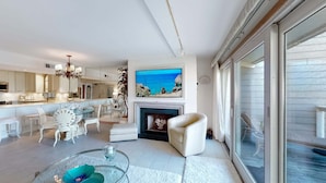 Una sala moderna con chimenea, televisor y comedor.