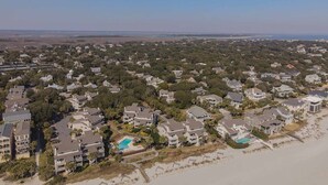 Un área residencial costera con casas, una playa y una vista despejada del océano.