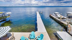 A dock extending into a calm lake with clear water, surrounded by boats and a small dock area with chairs and umbrellas. - Russell's Rendezvous - Enjoy a Vacation Full of Adventure! (Dresden)