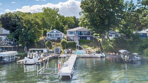 A waterfront property with a dock, boats, and a house with a balcony overlooking the water. - Russell's Rendezvous - Enjoy a Vacation Full of Adventure! (Dresden)