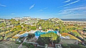 A resort with multiple-story buildings, a central swimming pool, and a beachfront view. - Gorgeous dual-level ocean view unit located in Wild Dunes (Isle of Palms)