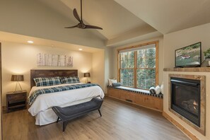 A bedroom with a bed, bench, ceiling fan, window, fireplace, and artwork. - Largest Black Bear Townhome - Ping Pong Table - on Demand Ski Shuttle (Durango)