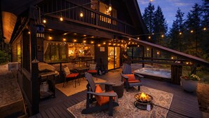 A wooden cabin with a deck, outdoor seating, and a fire pit. - Thyme Out/ HotTub, WIFI, Fenced Dog Space, Forest (Leavenworth)