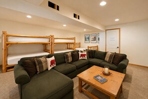 A room with bunk beds, a sectional sofa, and a coffee table. - On Fish Lake | Views | Private Dock | Deck | BBQ (Leavenworth)