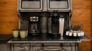 Pieni keittiönurkkaus, jossa on kahvinkeitin, Keurig-kahvinkeitin ja kahvikuppiteline.