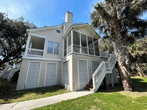 A two-story house with a balcony, a staircase, and a palm tree in the yard. - Traditional southern, pet friendly home (Isle of Palms)