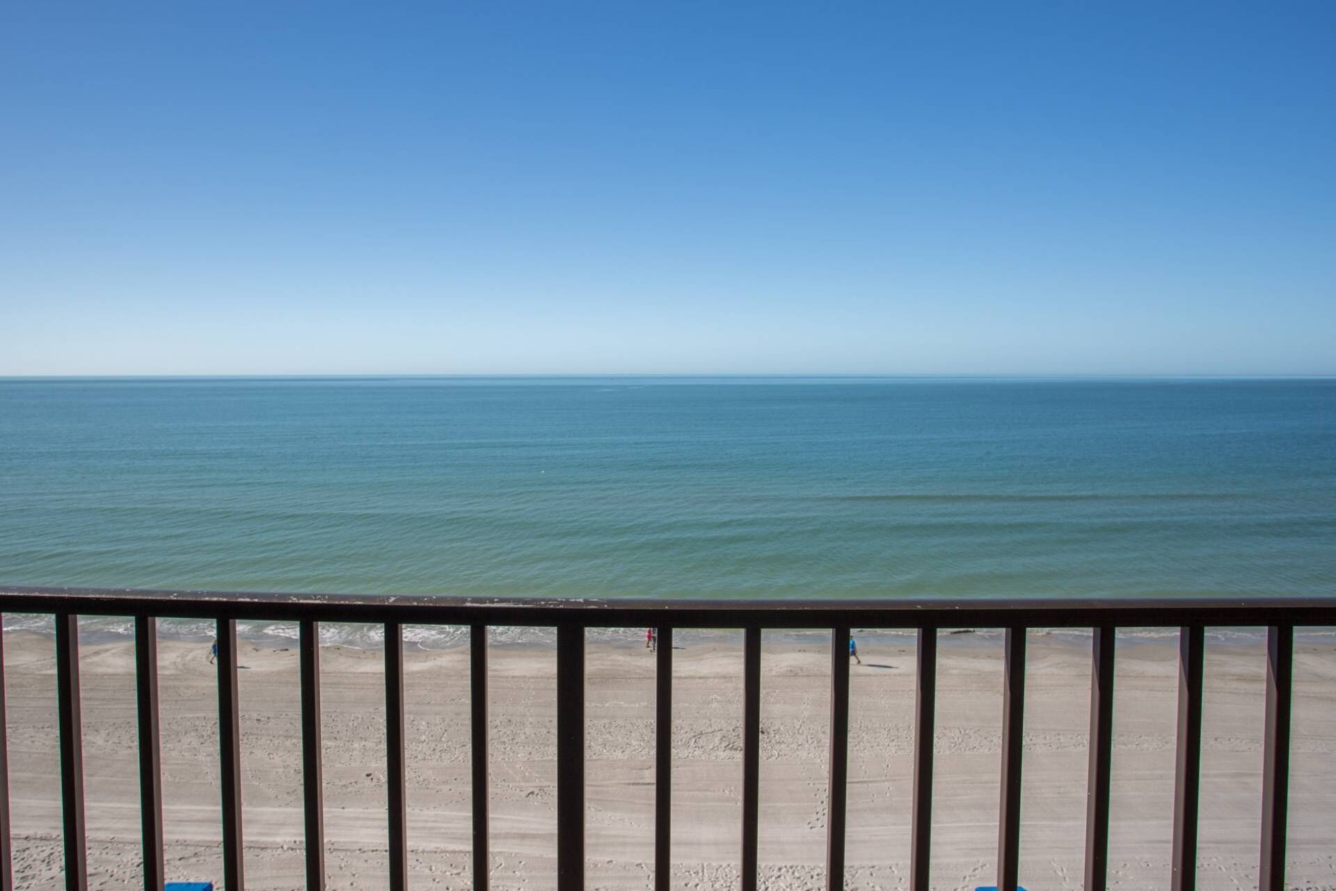 A view of a beach with a clear sky and calm sea.
