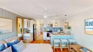 A modern kitchen with white cabinets, a central island, and pendant lighting.