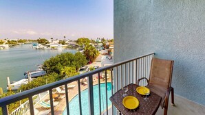 Een balkon met uitzicht op een jachthaven en een zwembad.