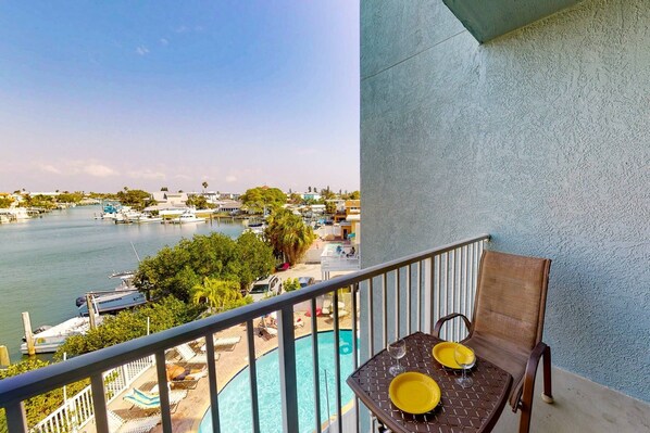 A balcony with a view of a marina and a pool area.