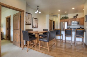 A spacious kitchen with wooden cabinets, a stainless steel refrigerator, and a built-in oven.