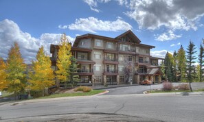 A multi-story hotel with a central courtyard, balconies, and a parking area.
