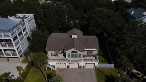 Een groot, twee verdiepingen tellend huis met een ruime voortuin, een oprit en een balkon.