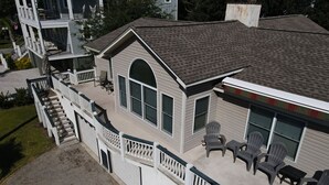 Een huis met twee verdiepingen en een overdekte patio met buitenmeubilair.