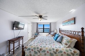 Relax in this cozy retreat with a large bed, ceiling fan, and city view.