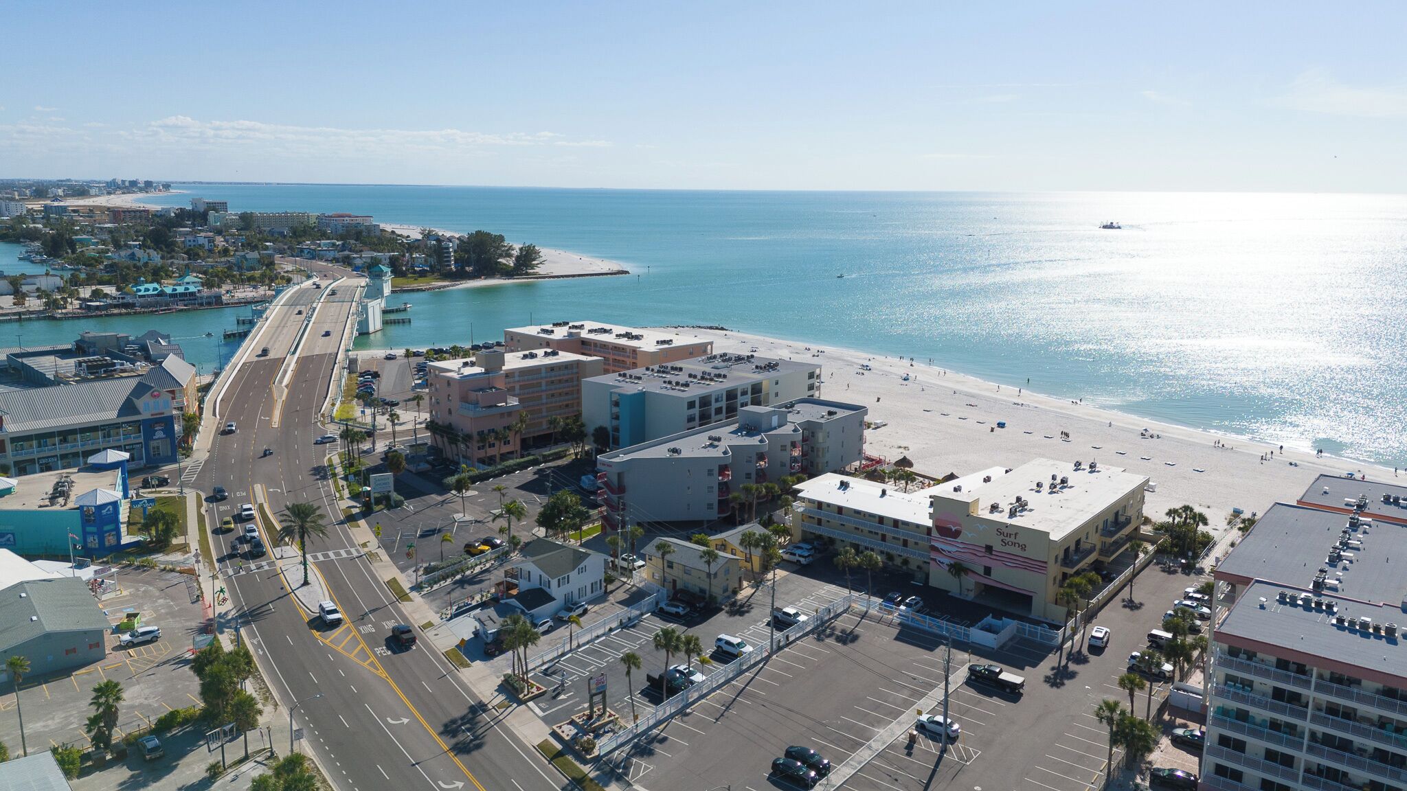 A coastal cityscape with a beachfront, buildings, and a road.
