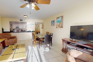 A living room with a TV, sofa, and dining area. - Spacious beachfront comfortable 3-bedroom 2-bath.  Heated pool.  Great location for a FL vacation. (Madeira Beach)