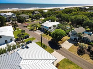 Ein Wohngebiet mit Häusern, einer Straße und einem Strand im Hintergrund.