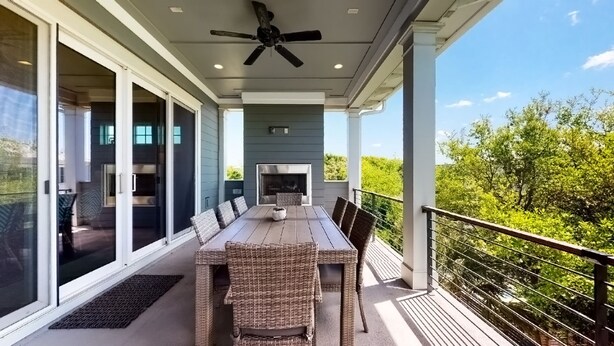 Un patio techado con una mesa de comedor, sillas y una chimenea.