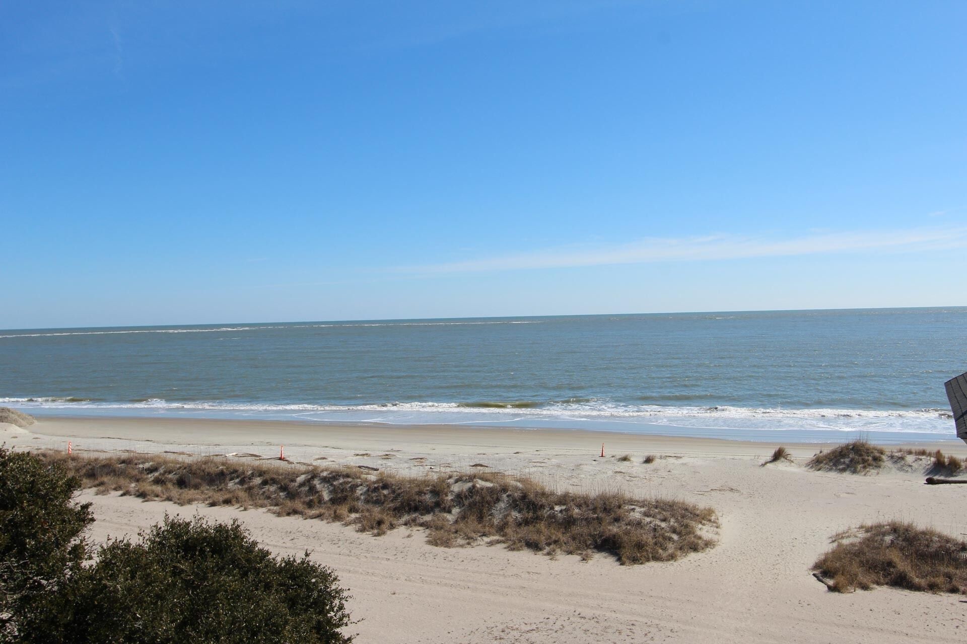 A beach with sand dunes and a clear view of the ocean.