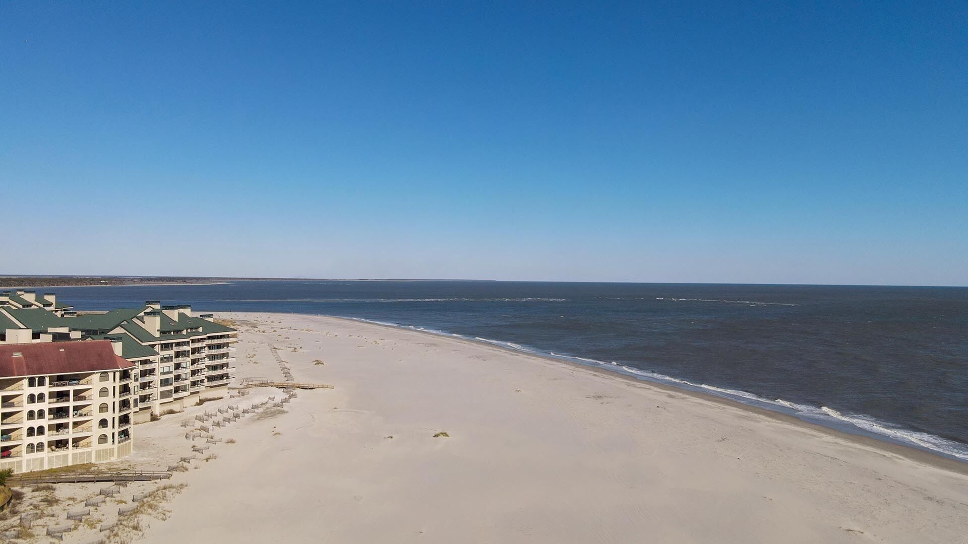 Een strand met een hotel op de voorgrond.