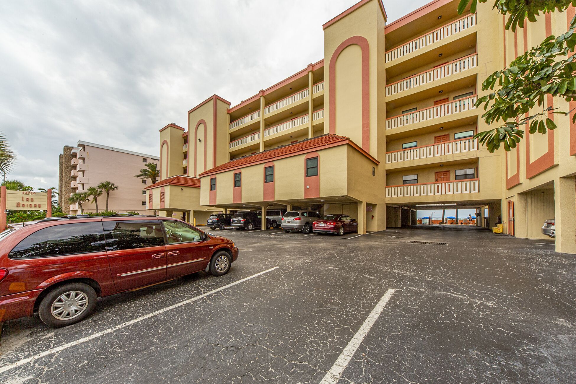 A multi-story hotel with a parking lot in front.