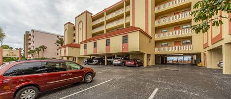 A multi-story hotel with a parking lot in front.