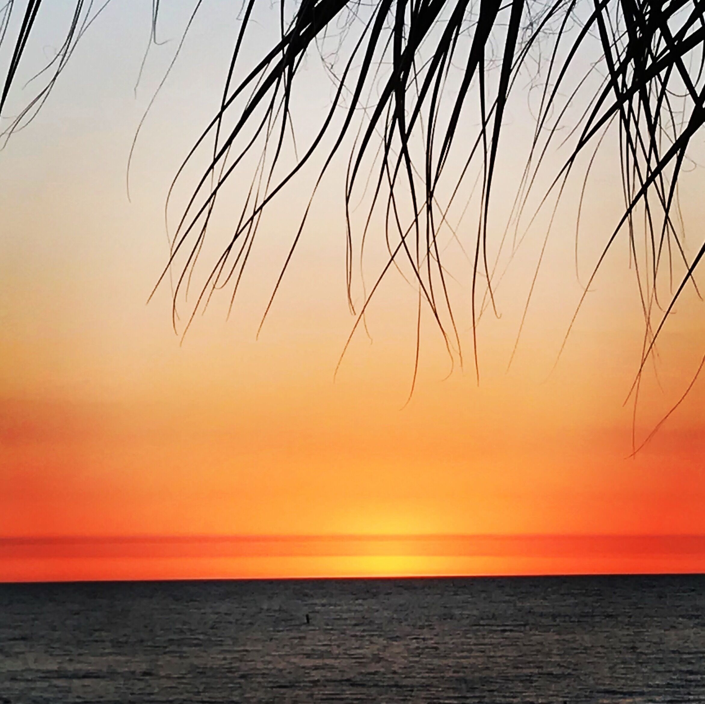 A sunset over the ocean with a view of the horizon.