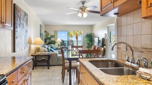 A kitchen with granite countertops, wooden cabinets, and a double sink. - Direct Oceanfront Views -  Madeira Norte #110 (Madeira Beach)