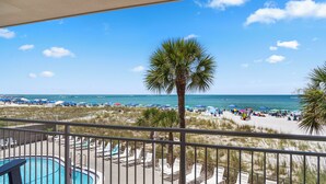 A pool area with lounge chairs and a view of the beach and ocean. - Direct Oceanfront Views -  Madeira Norte #110 (Madeira Beach)