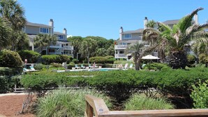 Un resort con edificios de varios pisos, una piscina y abundante vegetación.