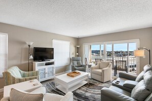 Relax in a spacious living room with a comfortable seating area, flat-screen TV, and city views.
