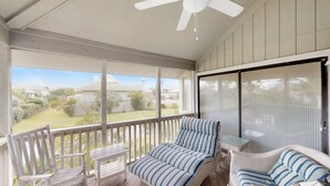 A covered porch with a ceiling fan, wicker furniture, and a view of a residential area. - Great home located near the beach with pool and tennis court access (Isle of Palms)