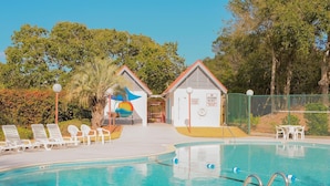 A swimming pool with lounge chairs, a lifeguard station, and a mural. - Great home located near the beach with pool and tennis court access (Isle of Palms)