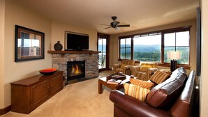 A living room with a stone fireplace, a television, and a sofa.