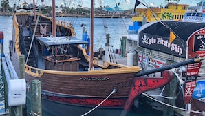A wooden boat named 'Royal Conquest' docked at a marina with a clear sky and a tropical backdrop. - Poolside 2b 2b Unit - 2nd Floor - Surf Song #224 (Madeira Beach)