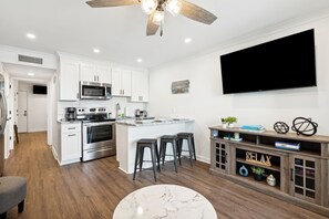 A modern kitchen with white cabinets, stainless steel appliances, and a large island with stools. - Beachfront Condo with Breathtaking Ocean Views! Updated Feb 2026! (Isle of Palms)