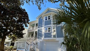 A two-story house with a front porch, a staircase, and a garage. - Beautifully Updated Wild Dunes Luxury House (Isle of Palms)