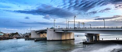 A bridge over a body of water with a clear sky and clouds.