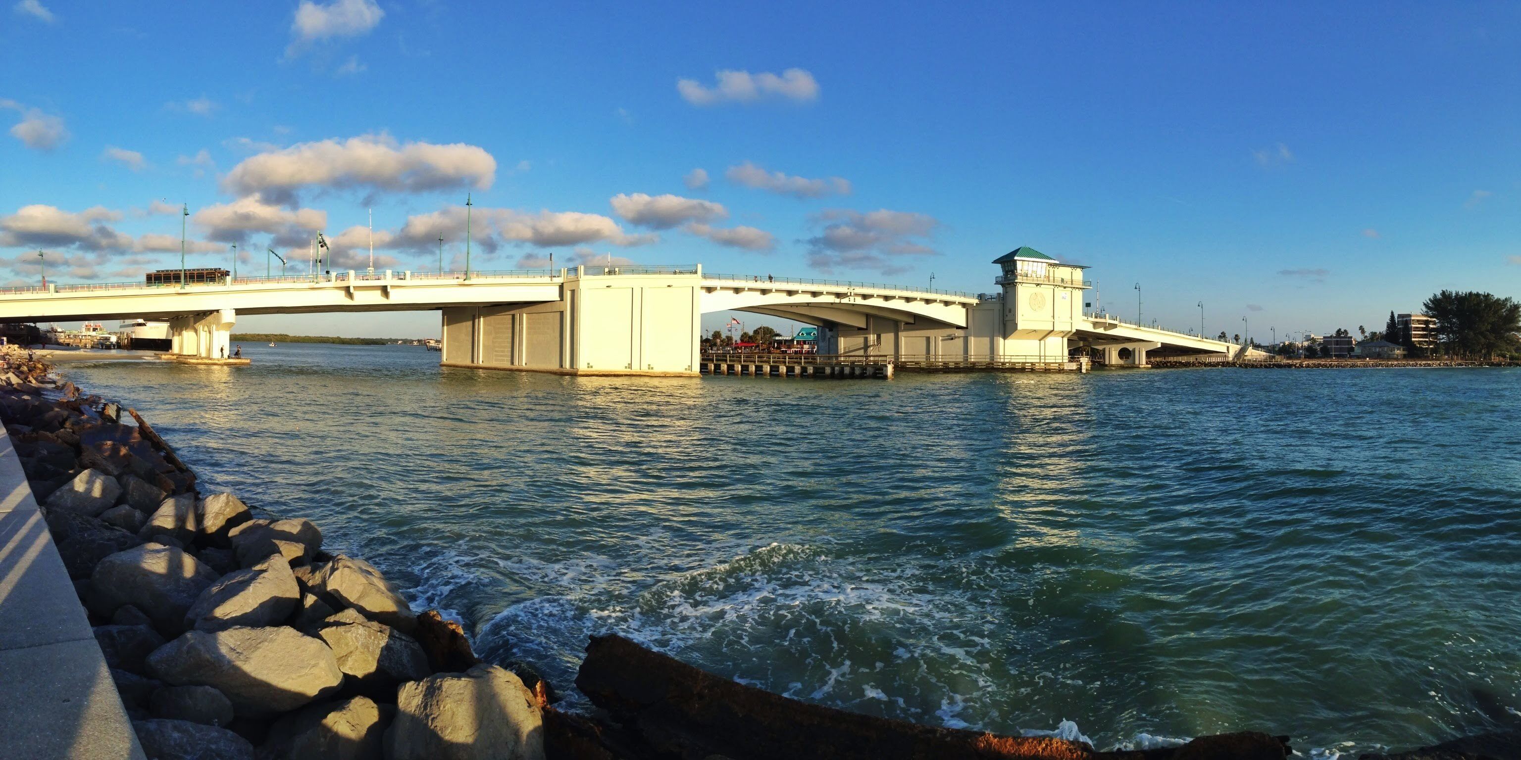 A bridge over a body of water with a control tower on the right side.
