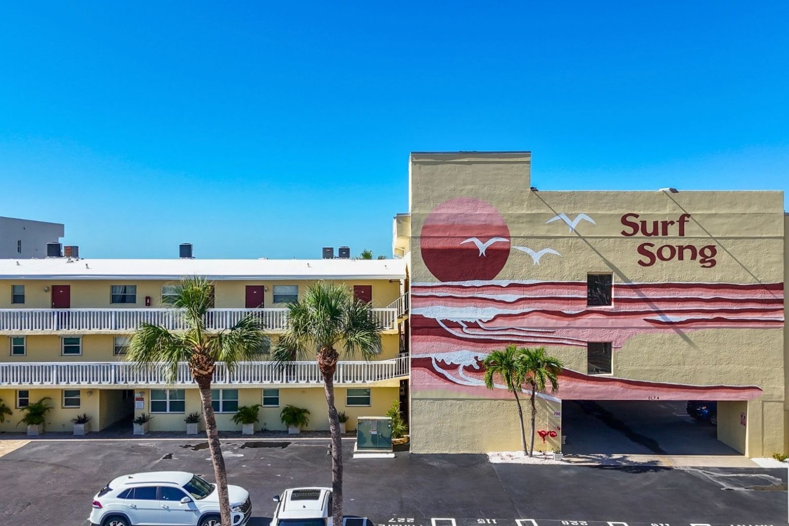 Un bâtiment orné d’une fresque représentant des vagues et des mouettes, portant l’inscription « Surf Song ».