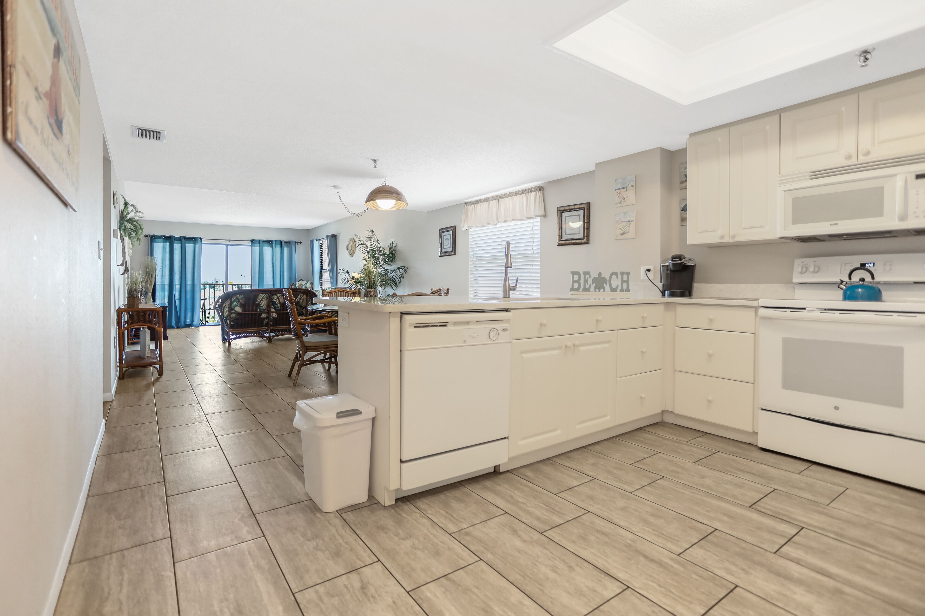 A modern kitchen with white cabinetry, a built-in oven, and a microwave.