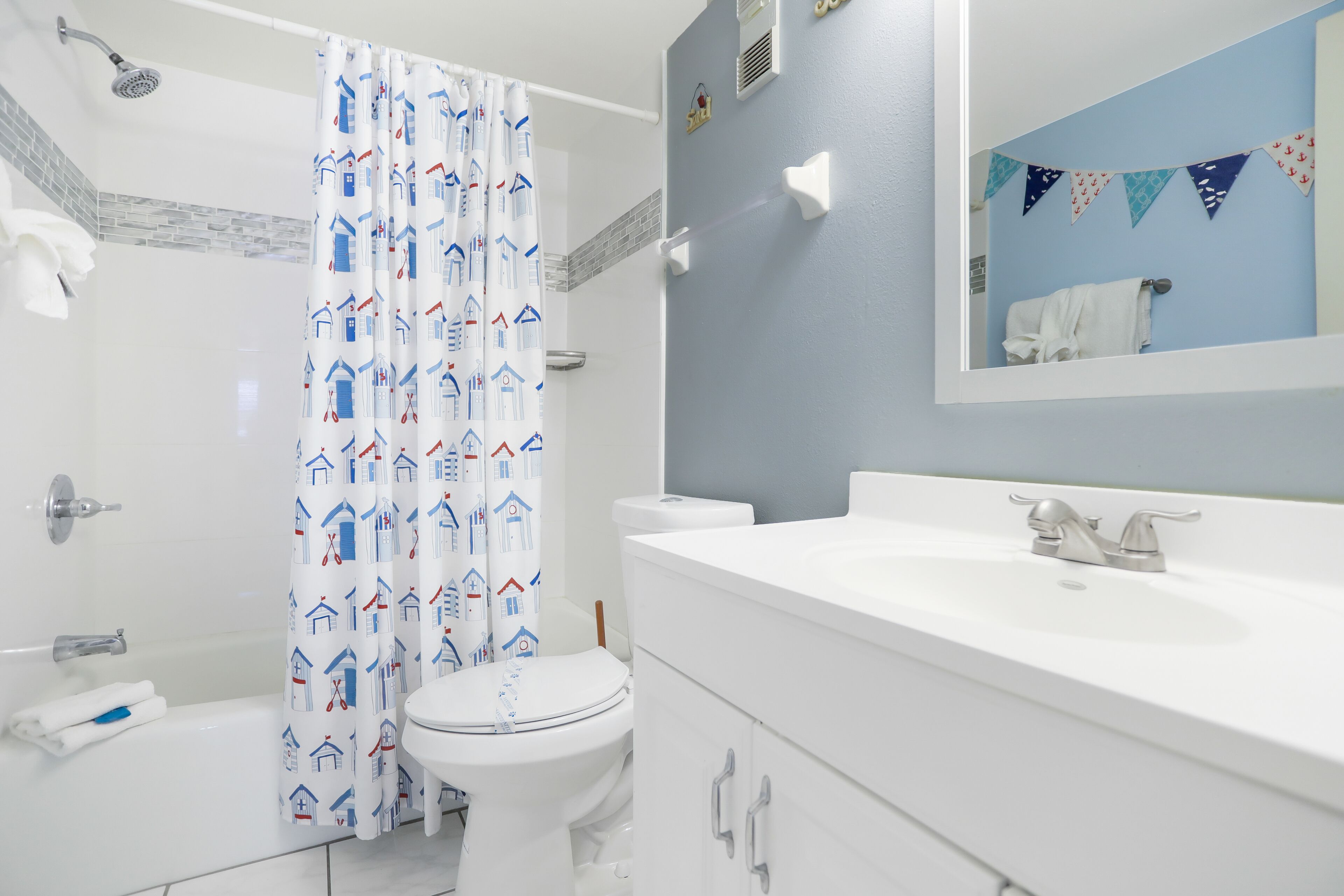 A bathroom with a shower, toilet, and sink.