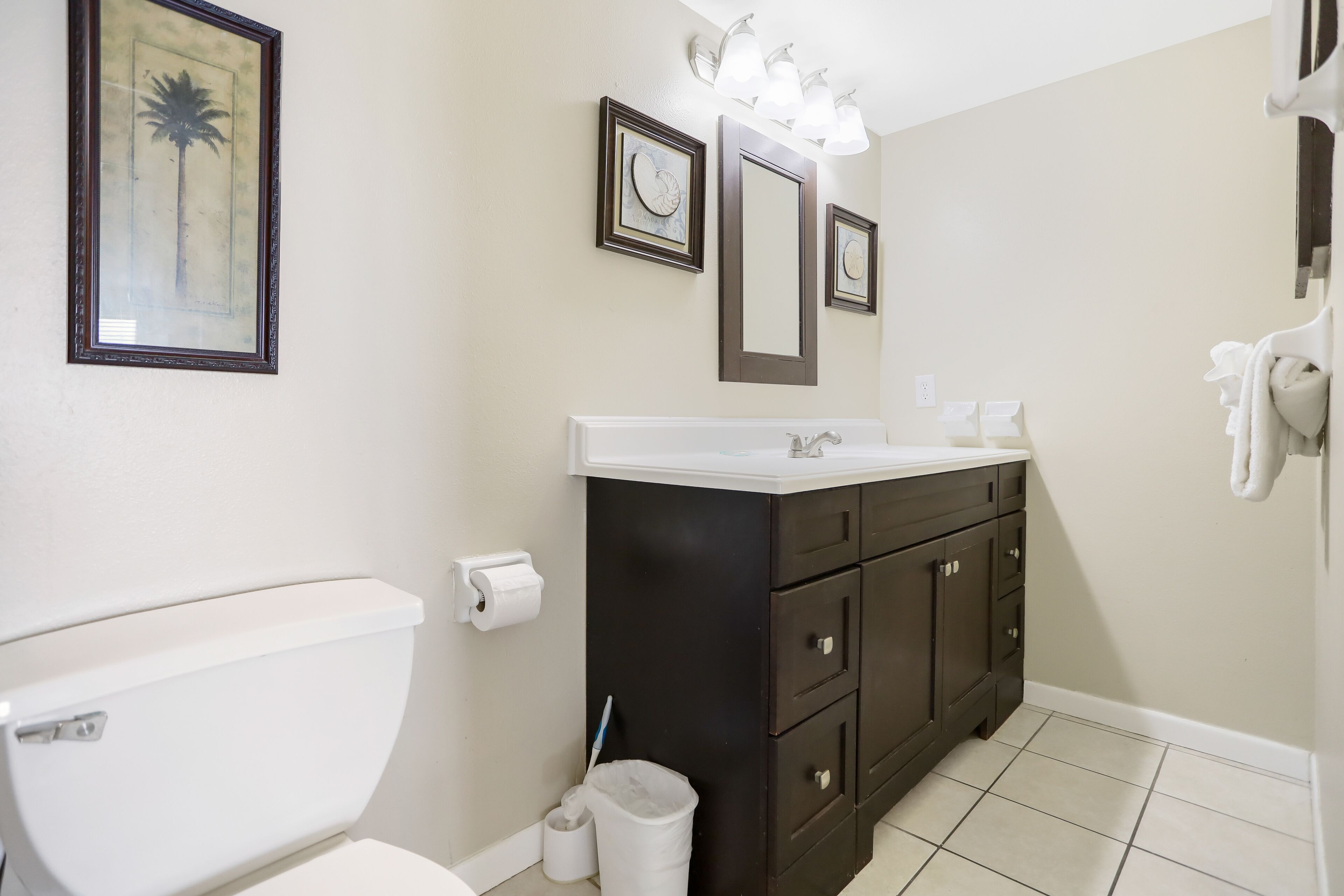 Une salle de bain avec des toilettes, un lavabo et un miroir.