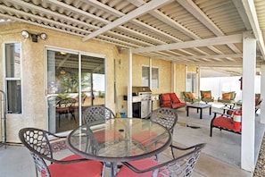 Relax in the shaded patio area, complete with a glass table and comfortable seating, and enjoy the convenience of an outdoor grill.