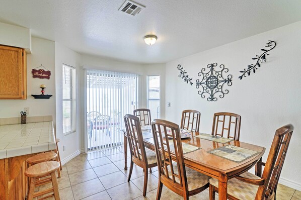 Enjoy meals in this dining area with a large table and six chairs, surrounded by a decorative wall art piece.